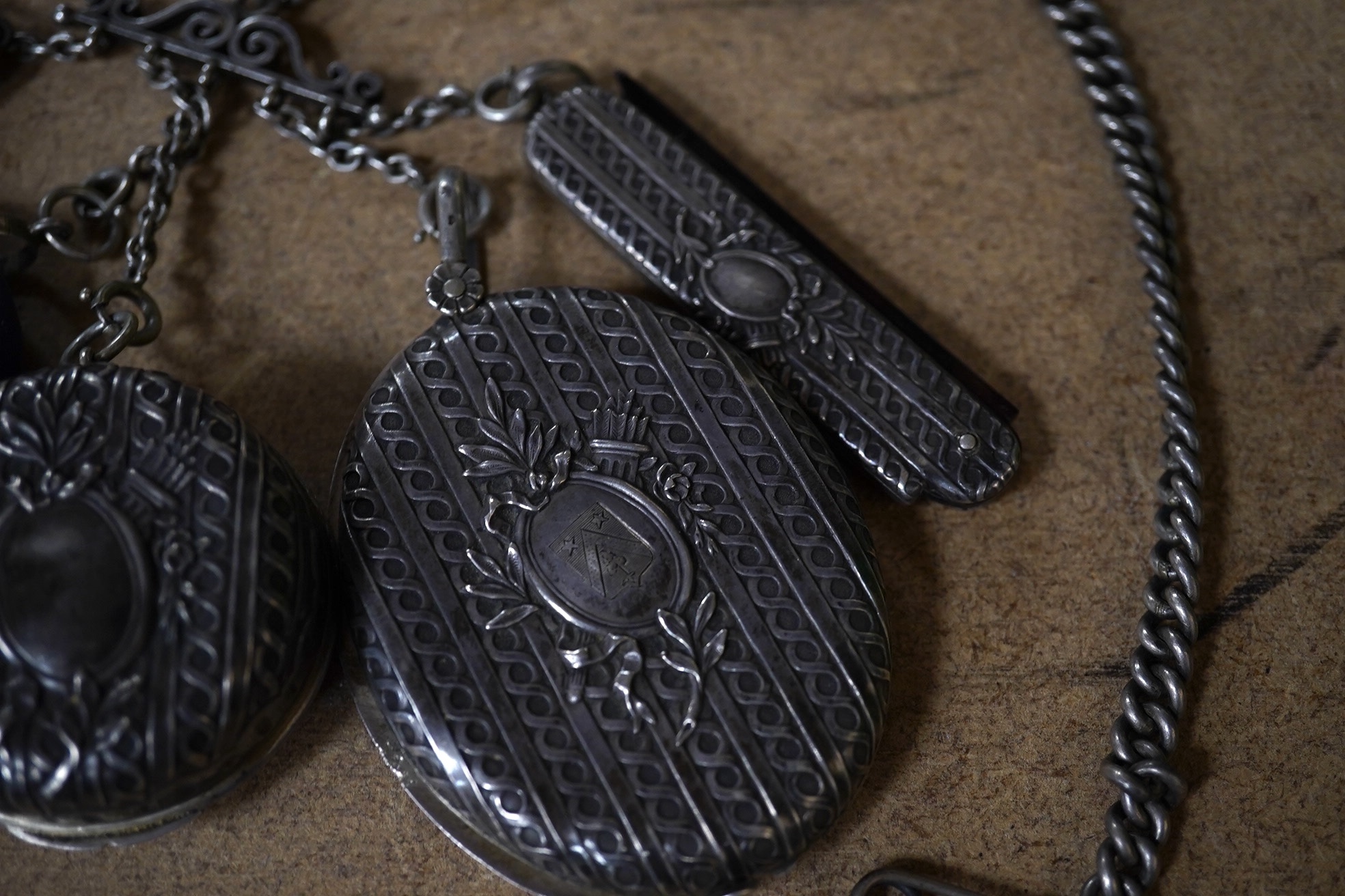 An early 20th century French white metal chatelaine, hung with six accoutrements including an associated silver vesta case, overall 35cm. Condition - fair